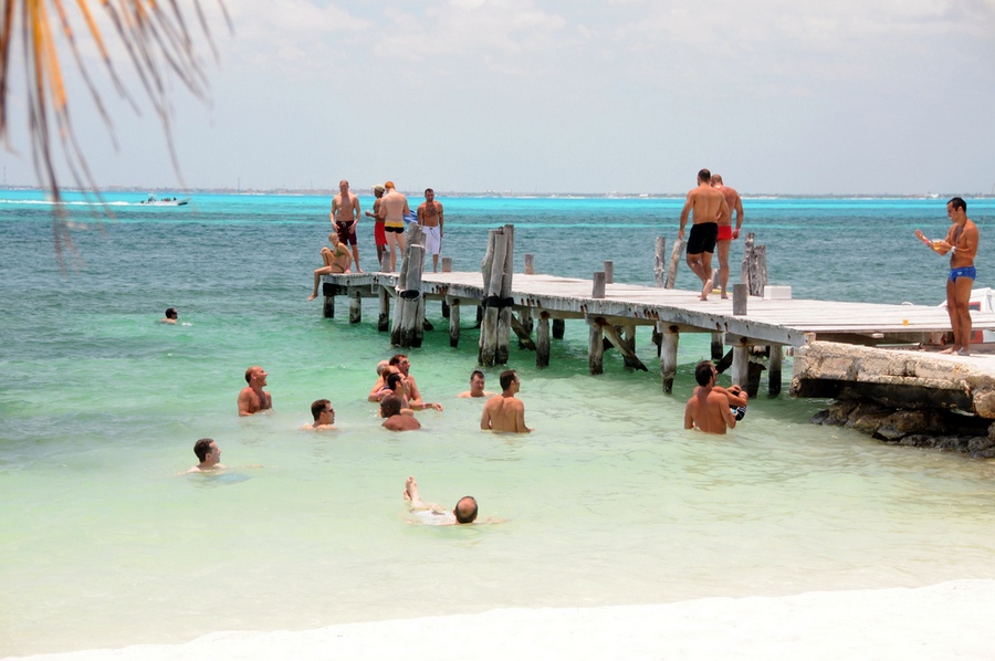 Chicos de un Atlantis gay cruise nadando después de almorzar en la Isla Mujeres